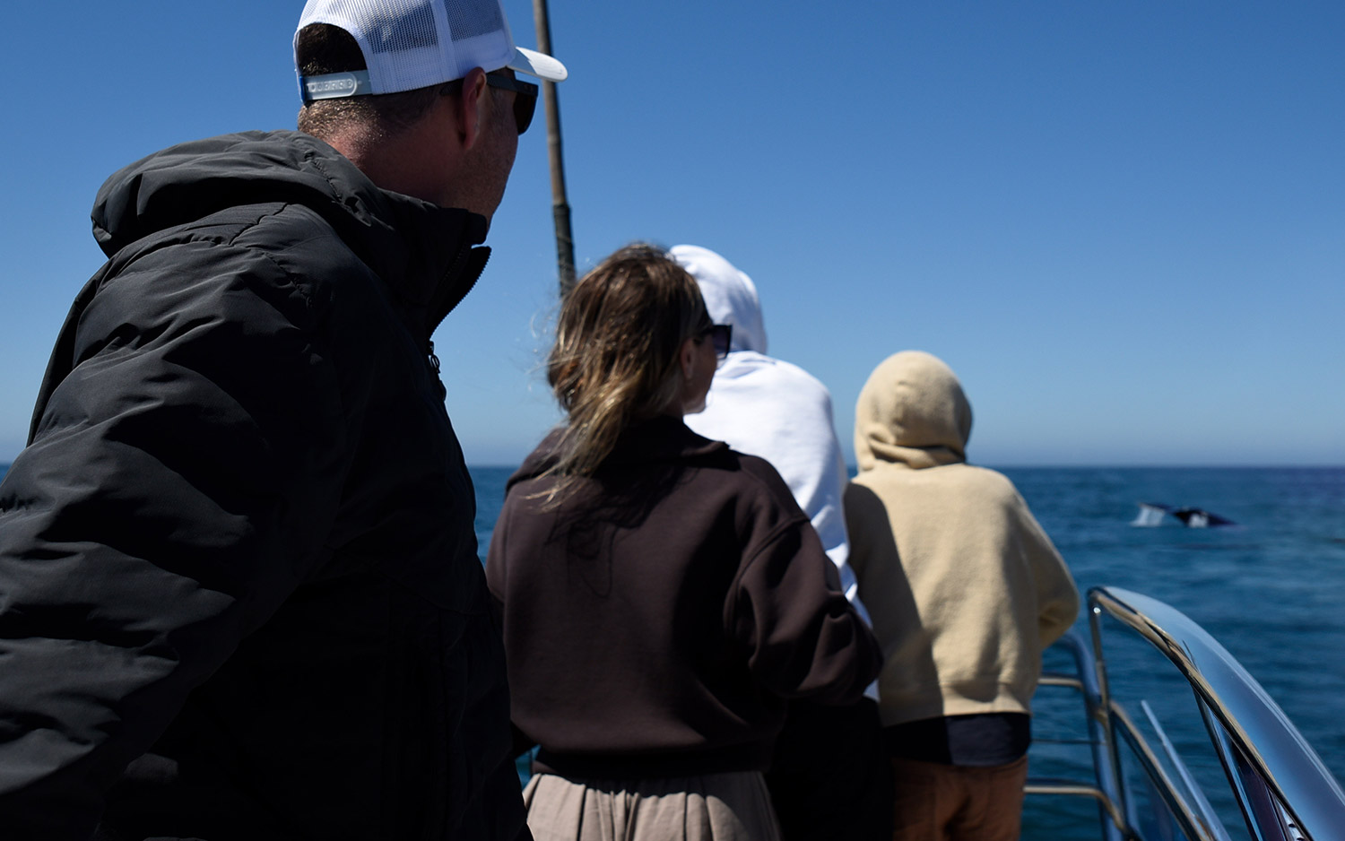 people wearing warm clothes on a boat in the ocean for a blog about How Depoe Bay Inspires a Slow Living Lifestyle